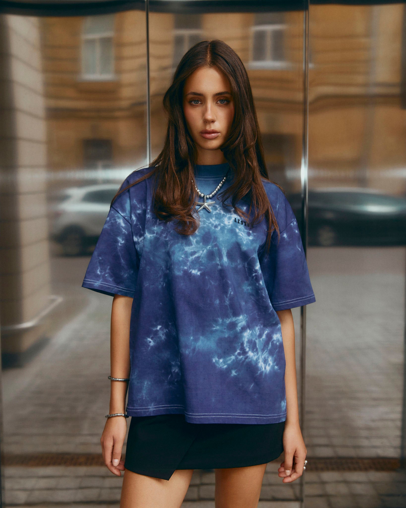 A blue and navy tie-dye short-sleeve t-shirt with a small black 'LISTEE' logo on the left chest, displayed flat against a light gray background.