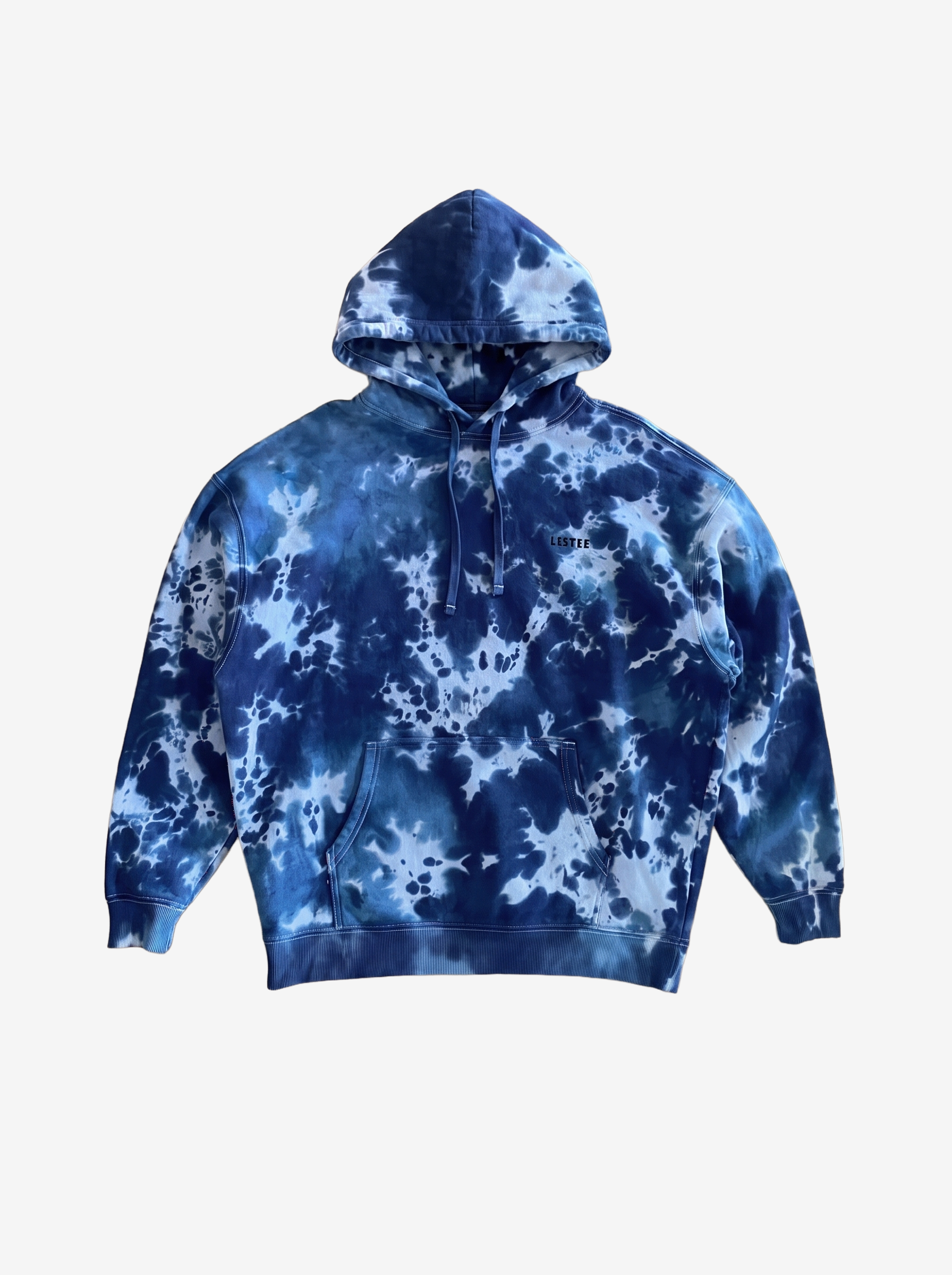 A navy blue and light blue tie-dye pullover hoodie with a drawstring hood and kangaroo pocket, displayed against a solid off-white background.